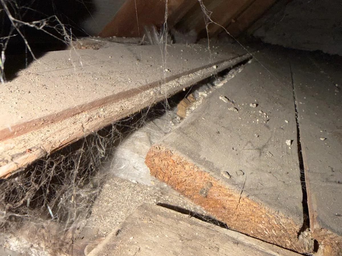 Dielenstoß mit Dämmmaterial auf dem Dachboden